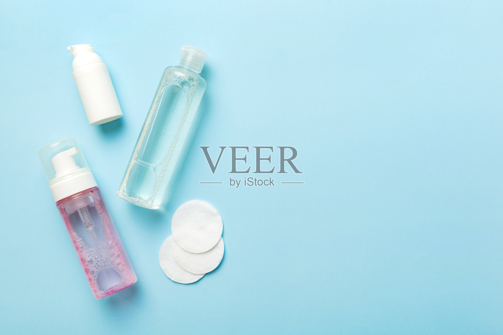 胶束清洁水和清洁盘，去除化妆品和清洁皮肤的彩色背景。复制空间俯视图照片摄影图片