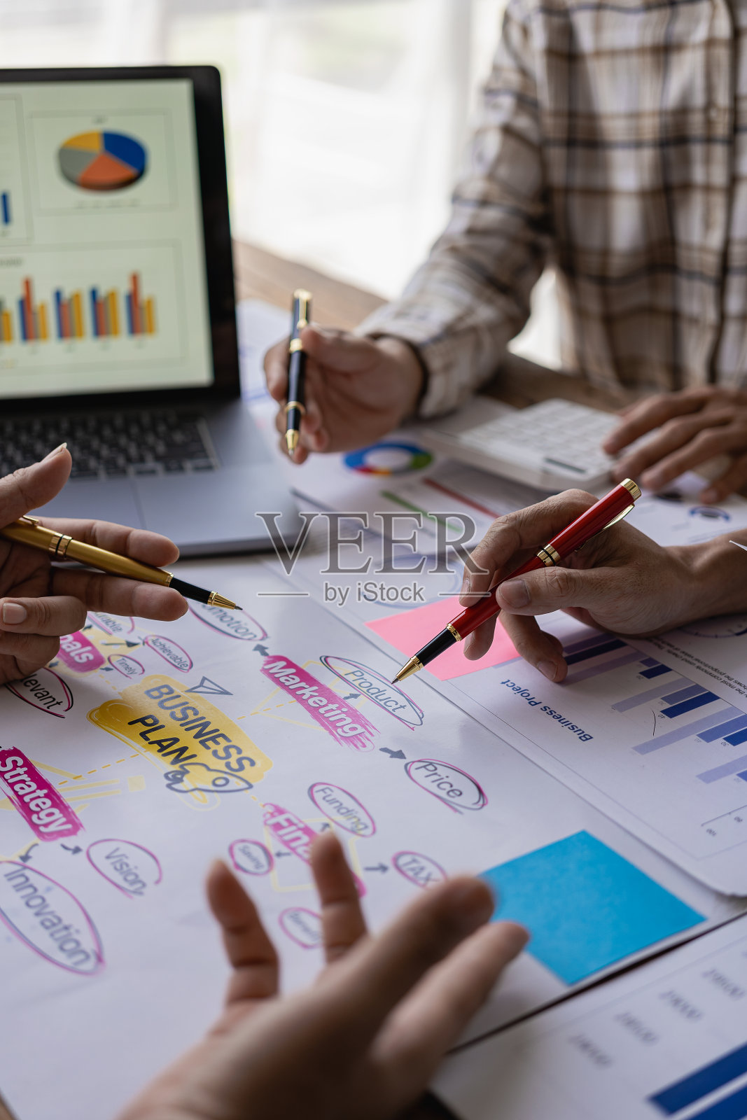 在公司会议讨论中，用笔记本电脑分析业务财务报告和笔记本电脑文档图表，展示团队合作的成功照片摄影图片