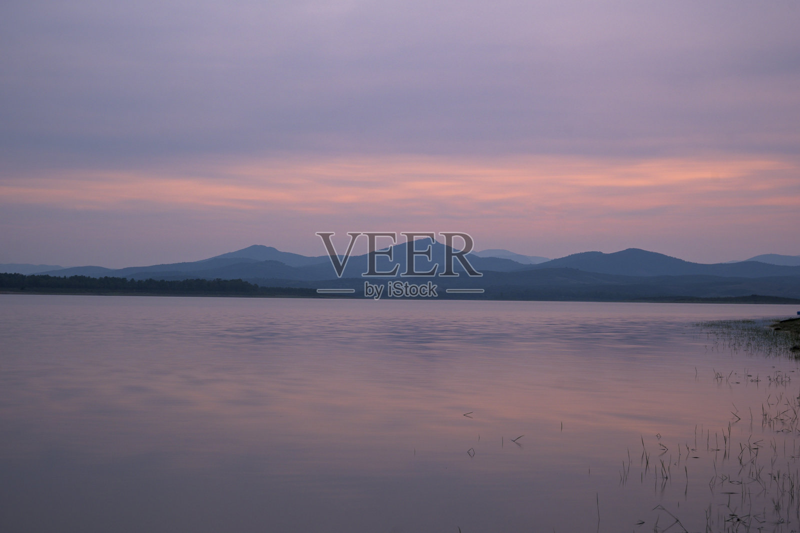 日落在加布里埃尔·加兰水库与山在背景和丝绸般的水照片摄影图片