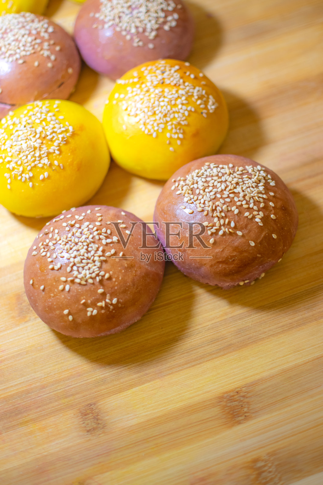 有趣的彩色手工汉堡面包与芝麻在木制背景照片摄影图片