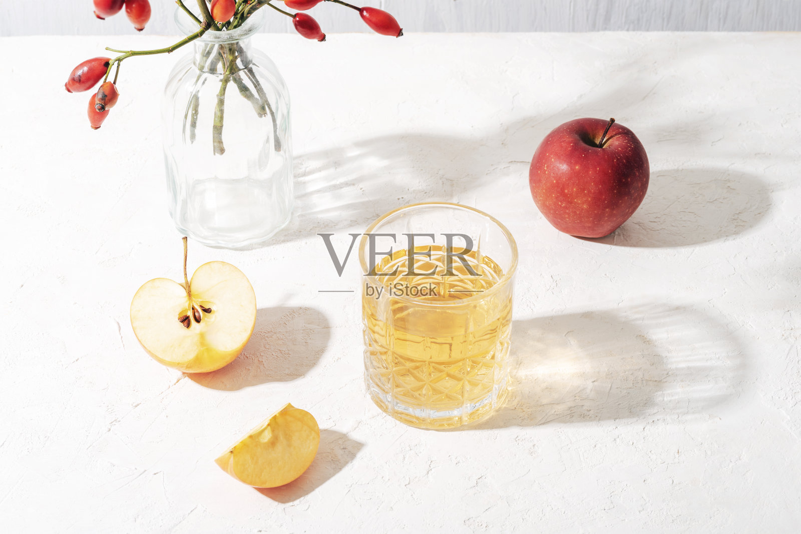 新鲜成熟的苹果和一杯苹果汁或苹果酒放在阳光下的白色桌子上。秋收，感恩观念。俯视图照片摄影图片