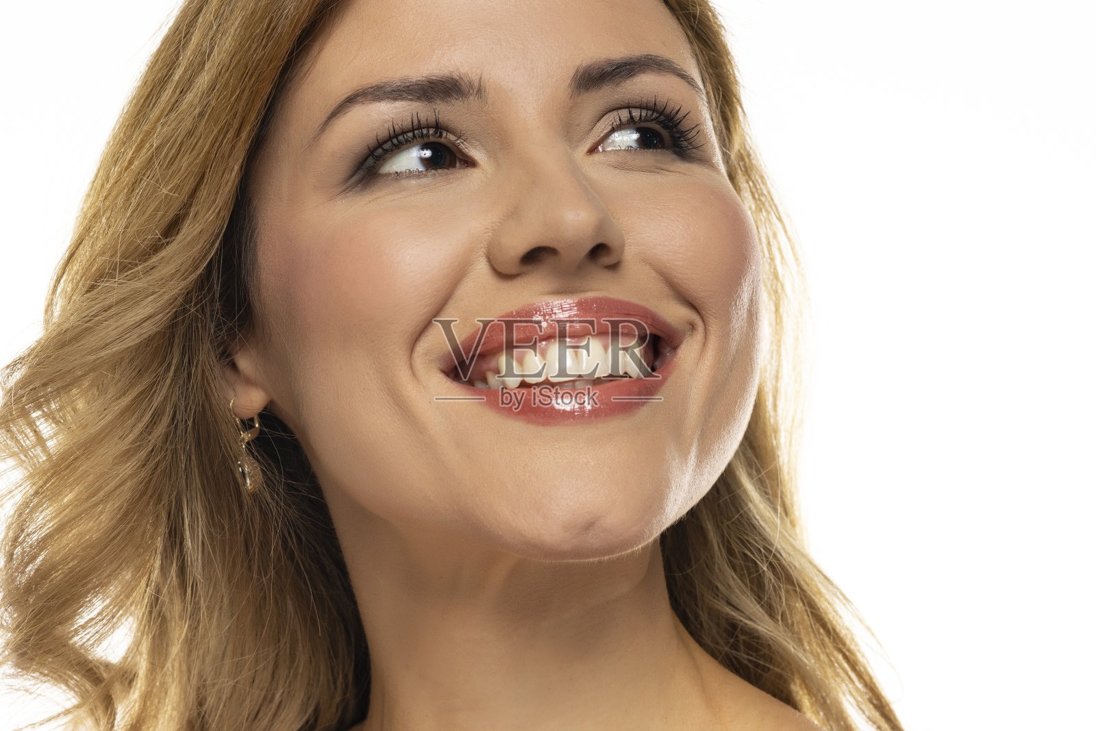 一幅迷人的肖像，一个迷人的女人展示了她完美无瑕，自然的牙齿和自信的微笑，散发着积极和健康的光芒。照片摄影图片