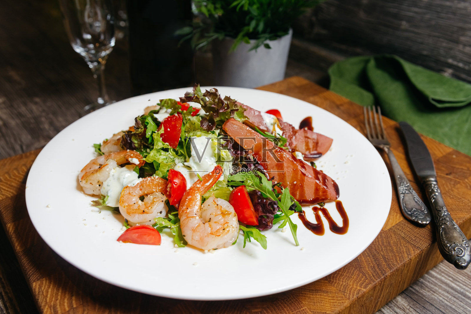 餐馆里用白盘子盛上的一种沙拉，里面有炸虾、用香醋做的调料、用红酒泡过的梨。照片摄影图片