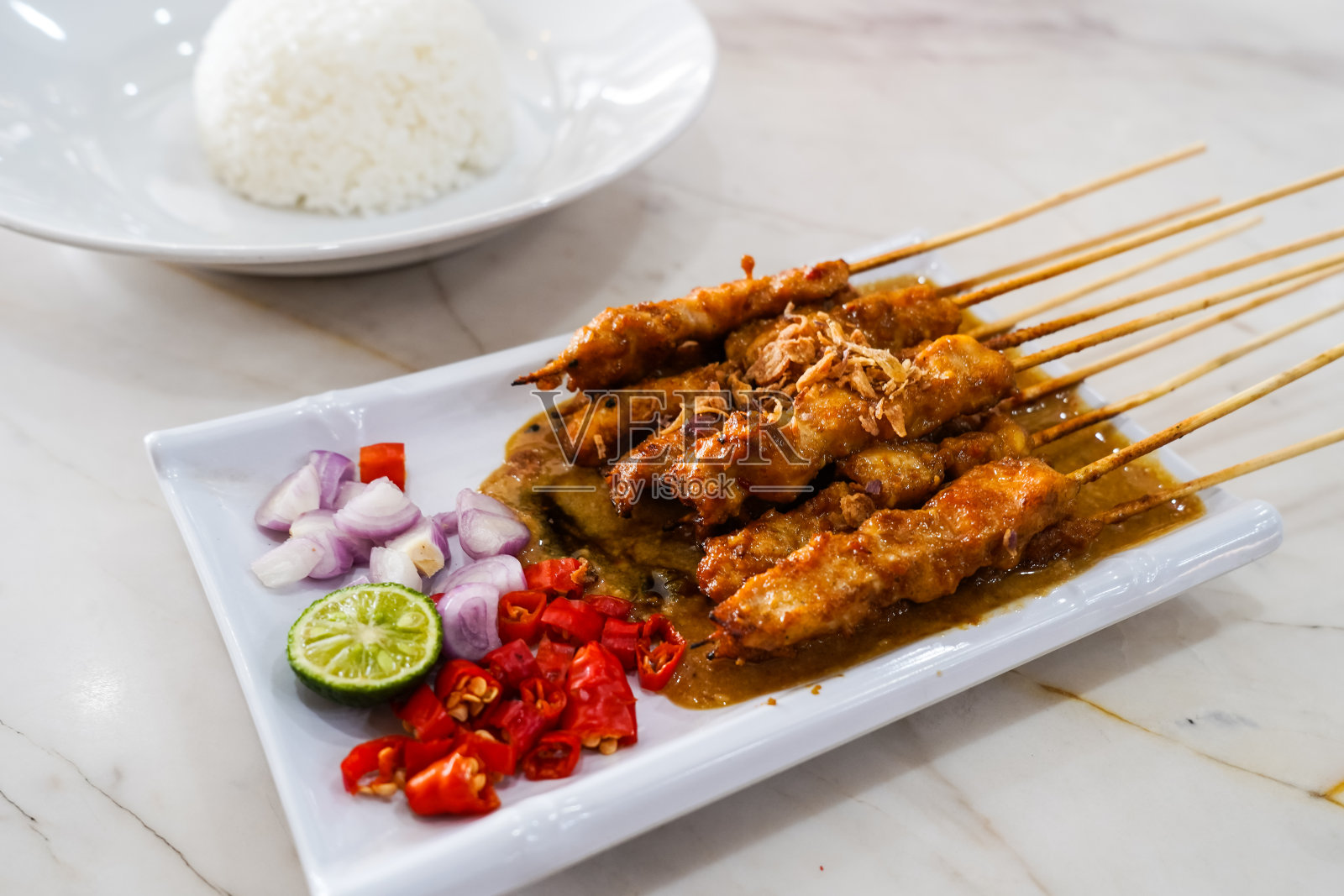 沙爹烤鸡沙爹。配上切片红辣椒、红洋葱和柠檬，照片摄影图片