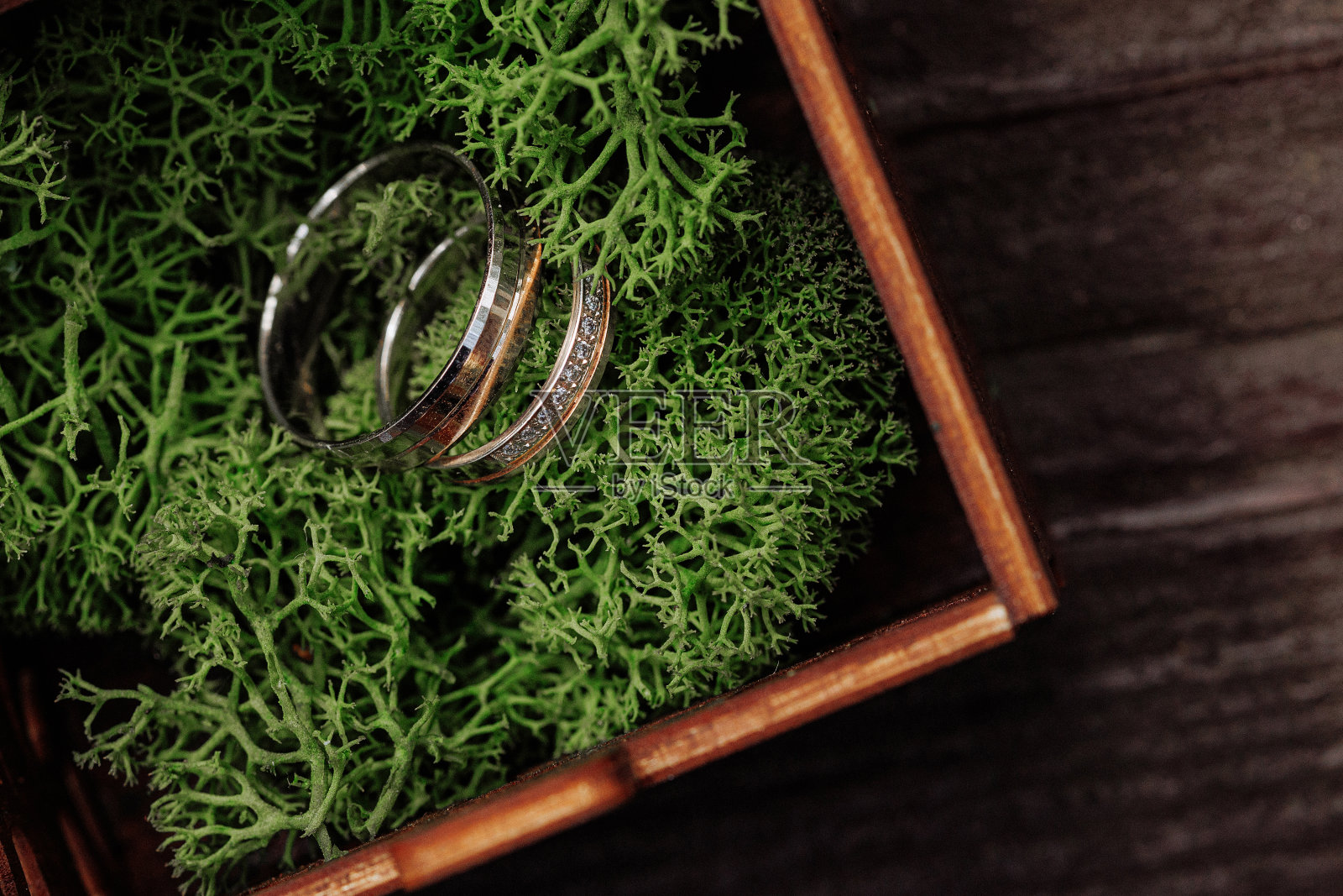 金结婚戒指在青苔木盒子照片摄影图片