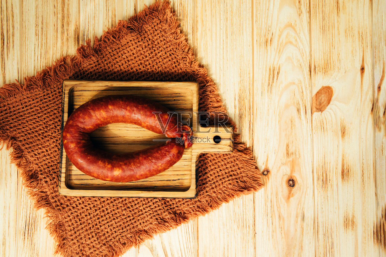 木制托盘上的圆香肠。熏香肠在浅色木制背景上照片摄影图片