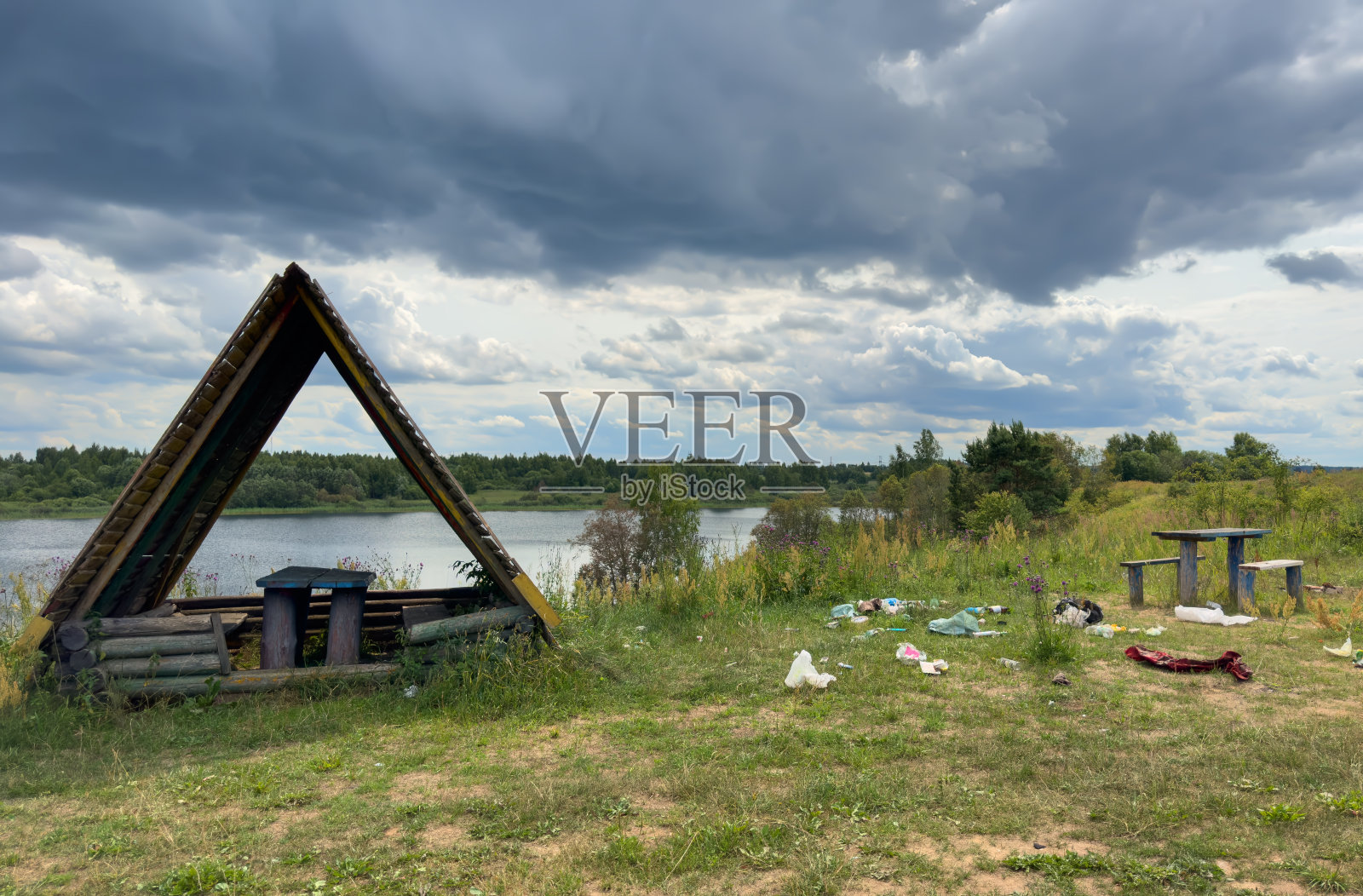 在非法地点倾倒垃圾。人们在大自然的湖泊附近扔垃圾。照片摄影图片