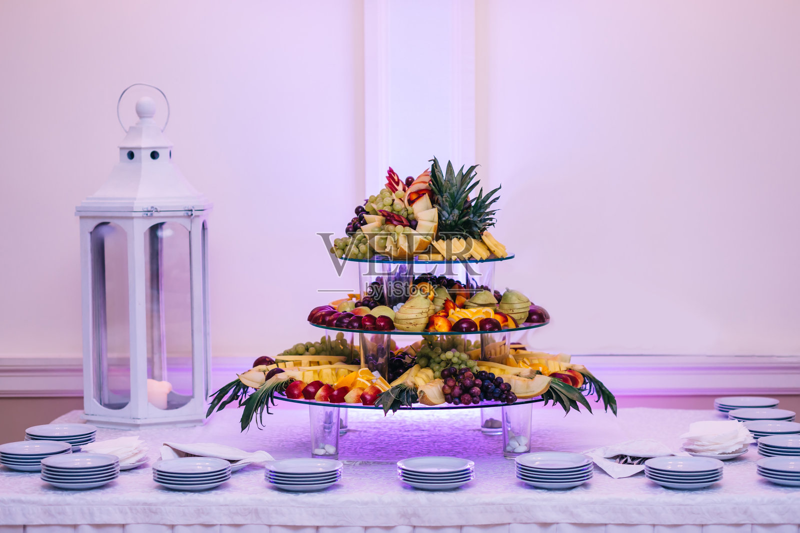 五颜六色的水果摆放在餐厅装饰精美的桌子上。照片摄影图片