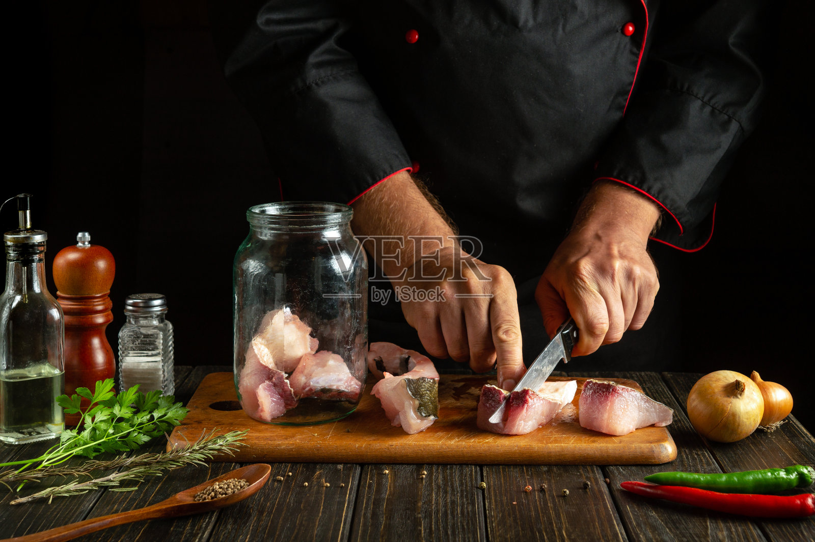 厨师在厨房的砧板上切生鱼。美味的咸鱼午餐，供餐馆或旅馆享用照片摄影图片