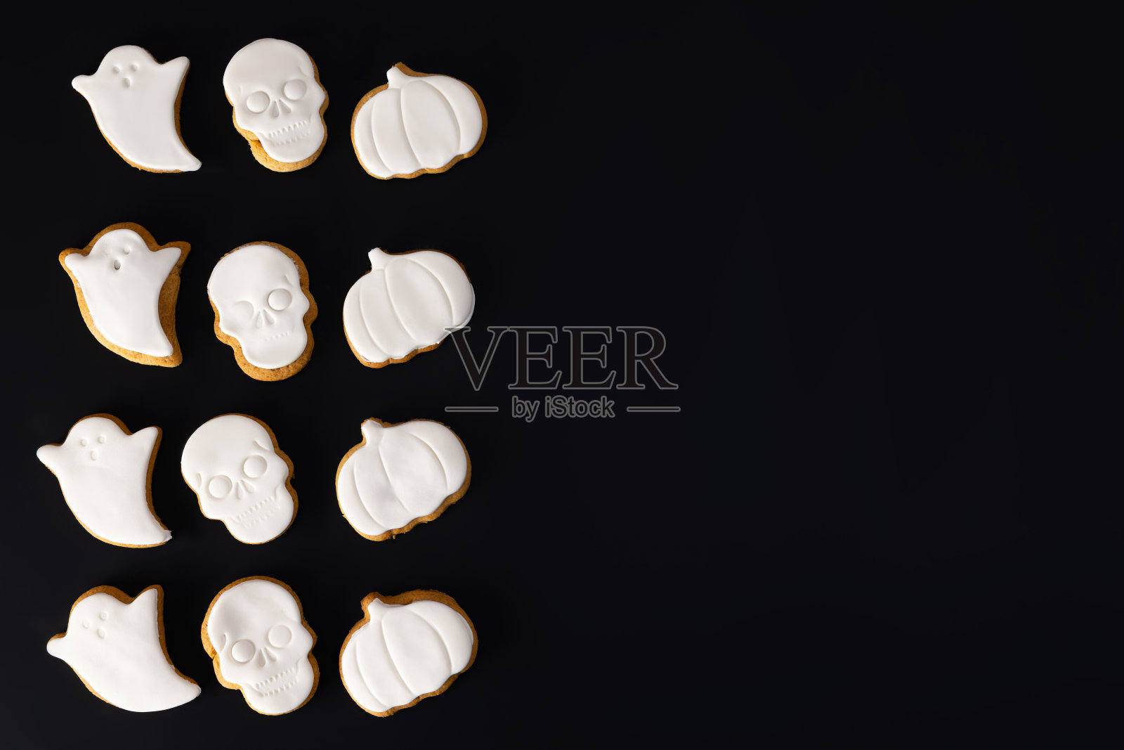 万圣节恐怖饼干与糖糖霜黑色背景，俯视图照片摄影图片