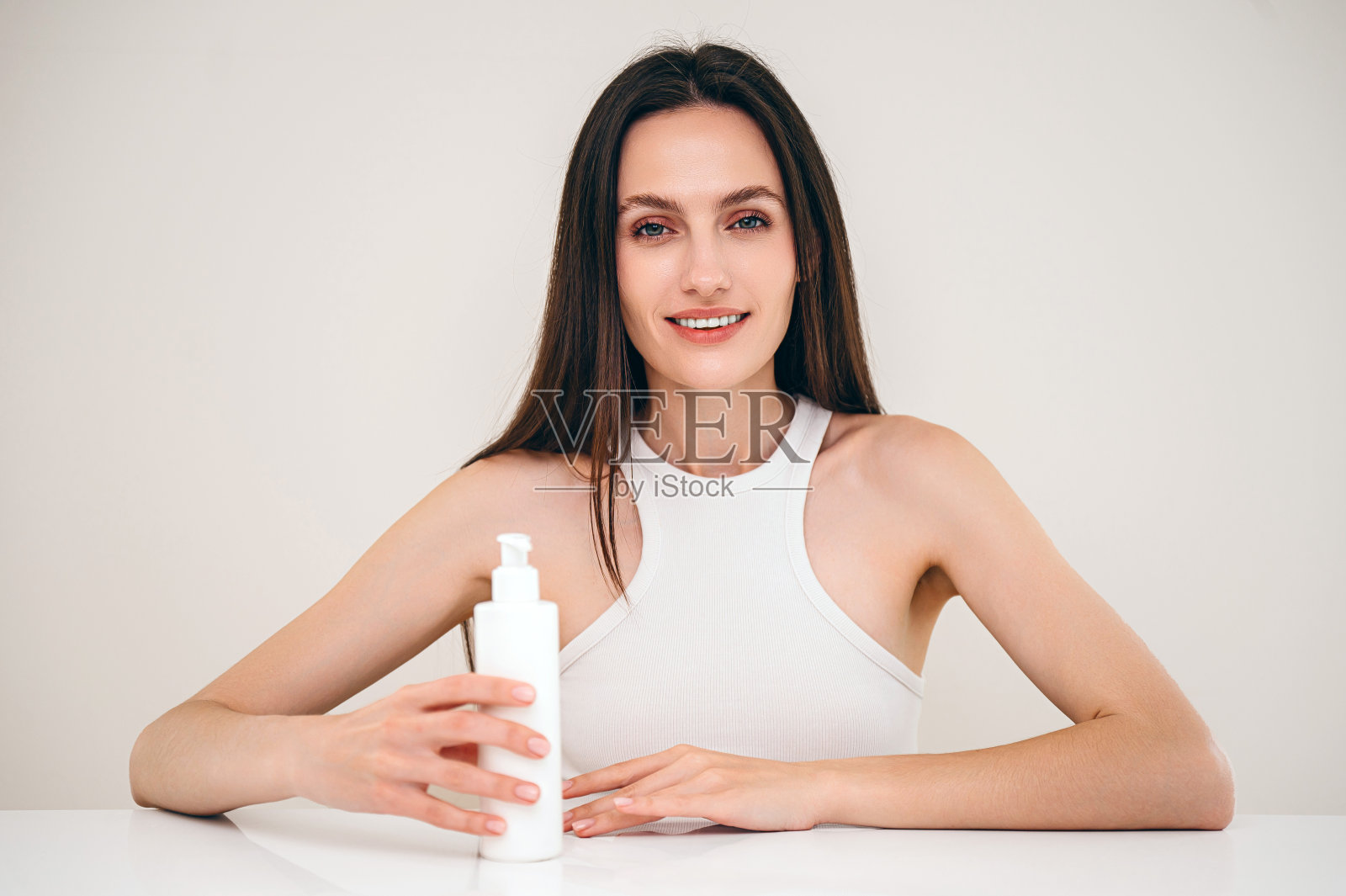 年轻女士用身体乳或保湿霜包装照片摄影图片