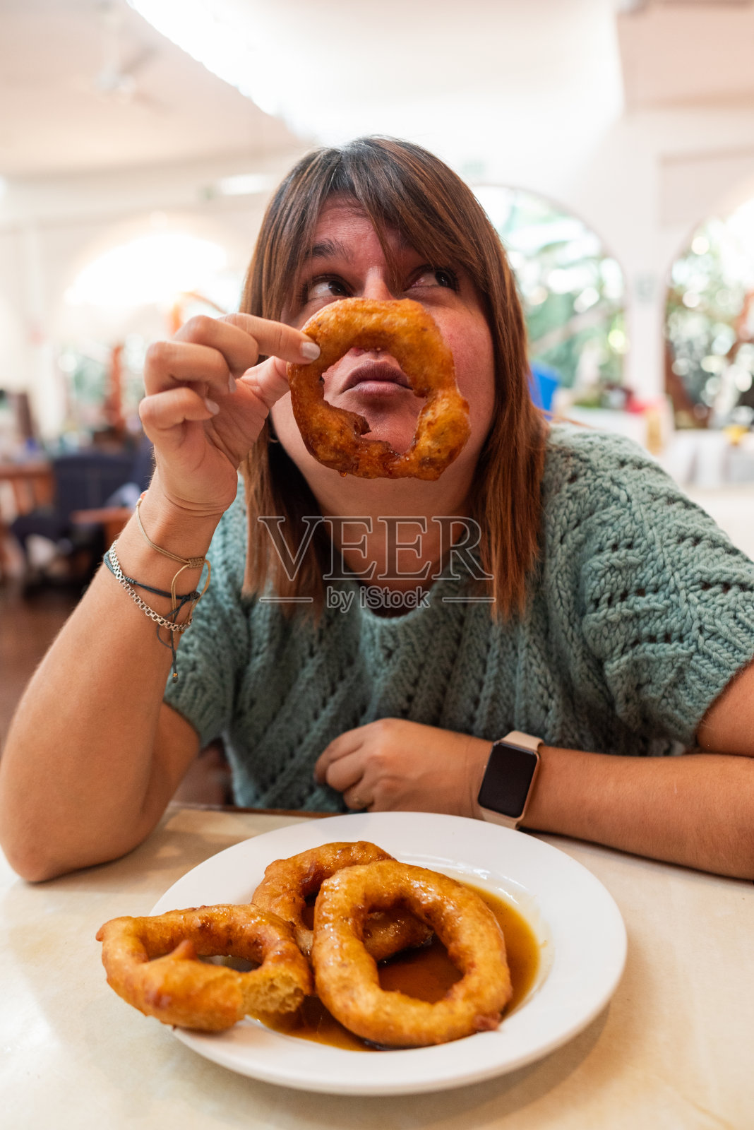 一个女人假装给皮卡龙一个吻。展示了它的美味。照片摄影图片