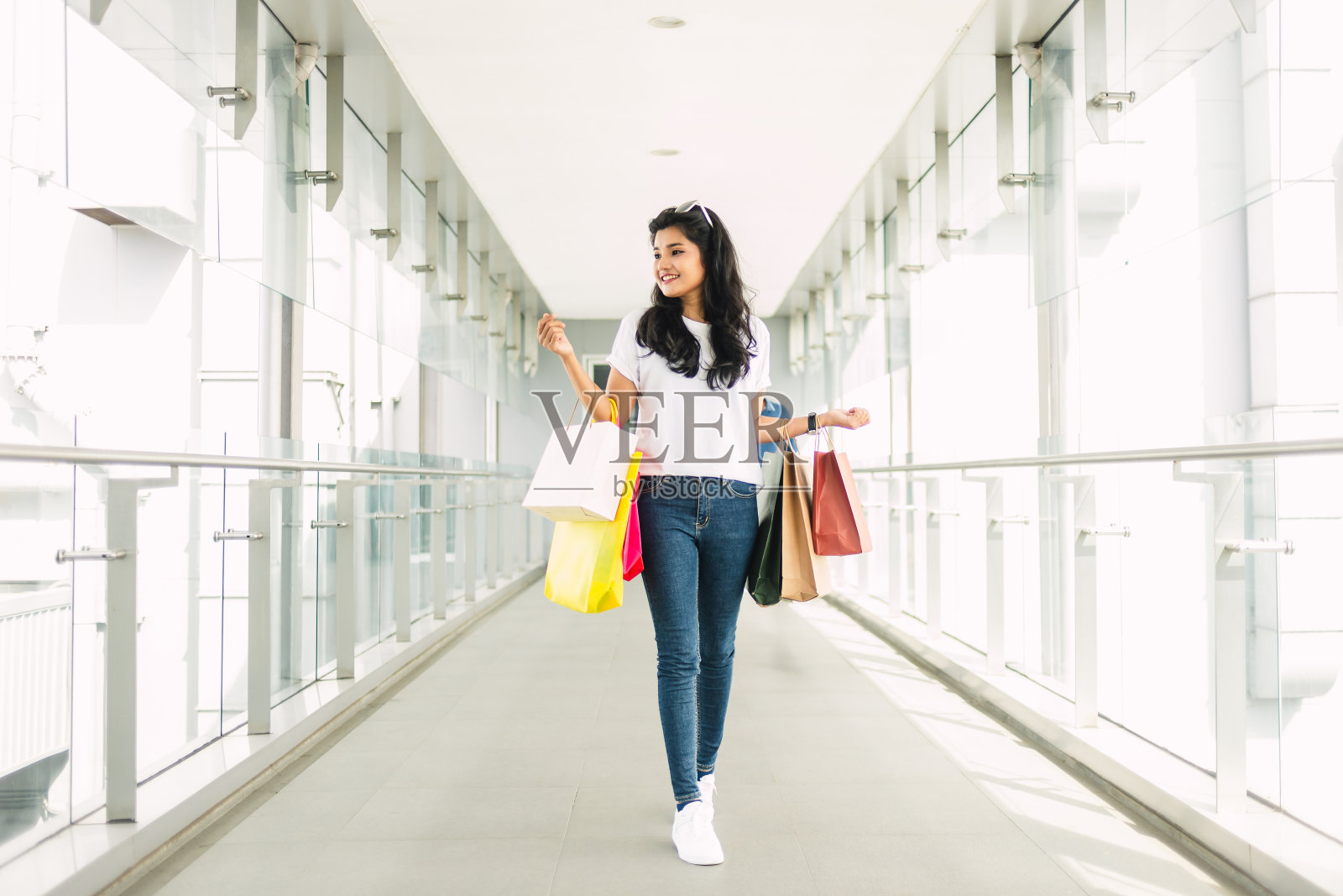 一个快乐的年轻女子在购物中心拿着购物袋照片摄影图片