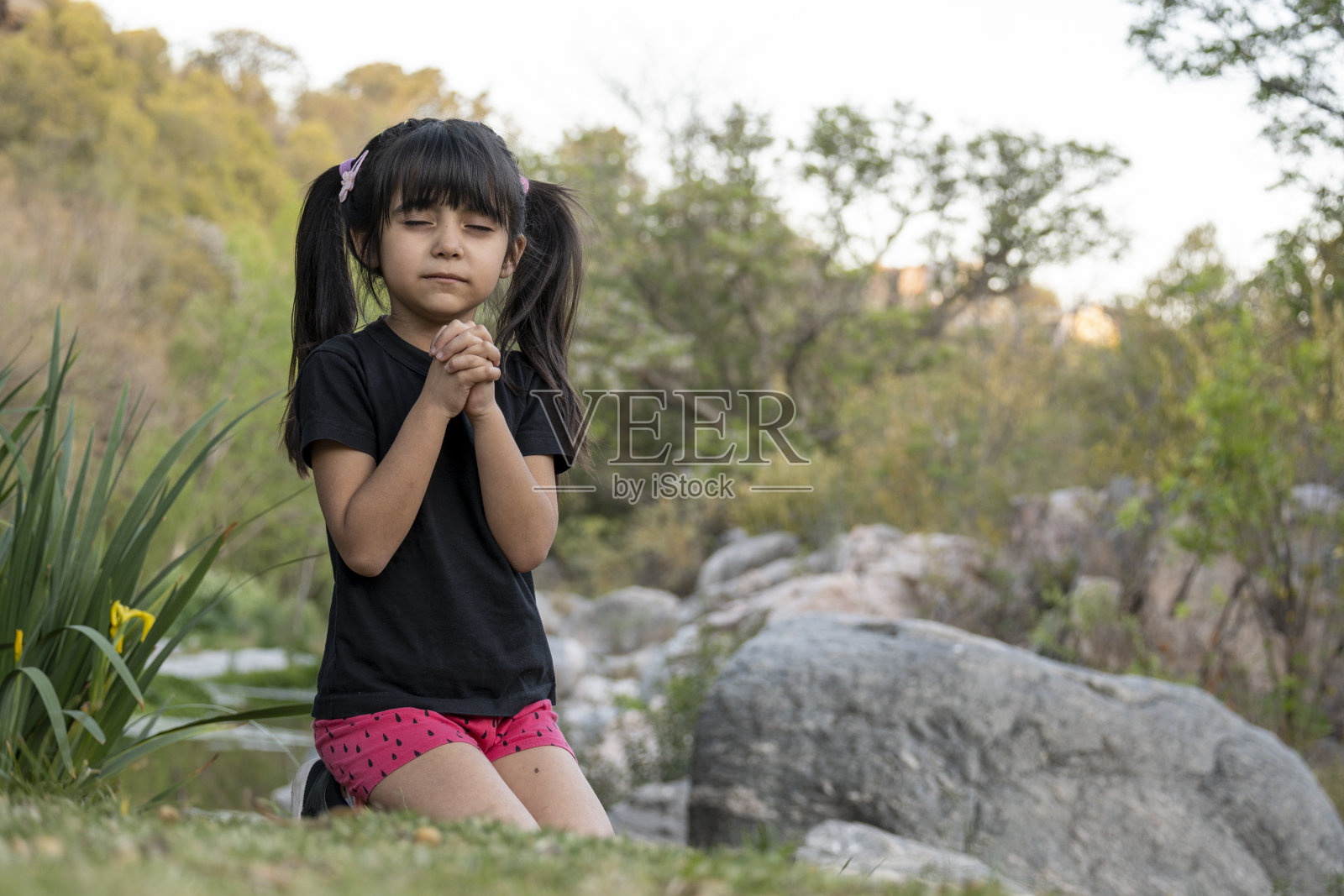 小女孩在小溪里玩耍。照片摄影图片