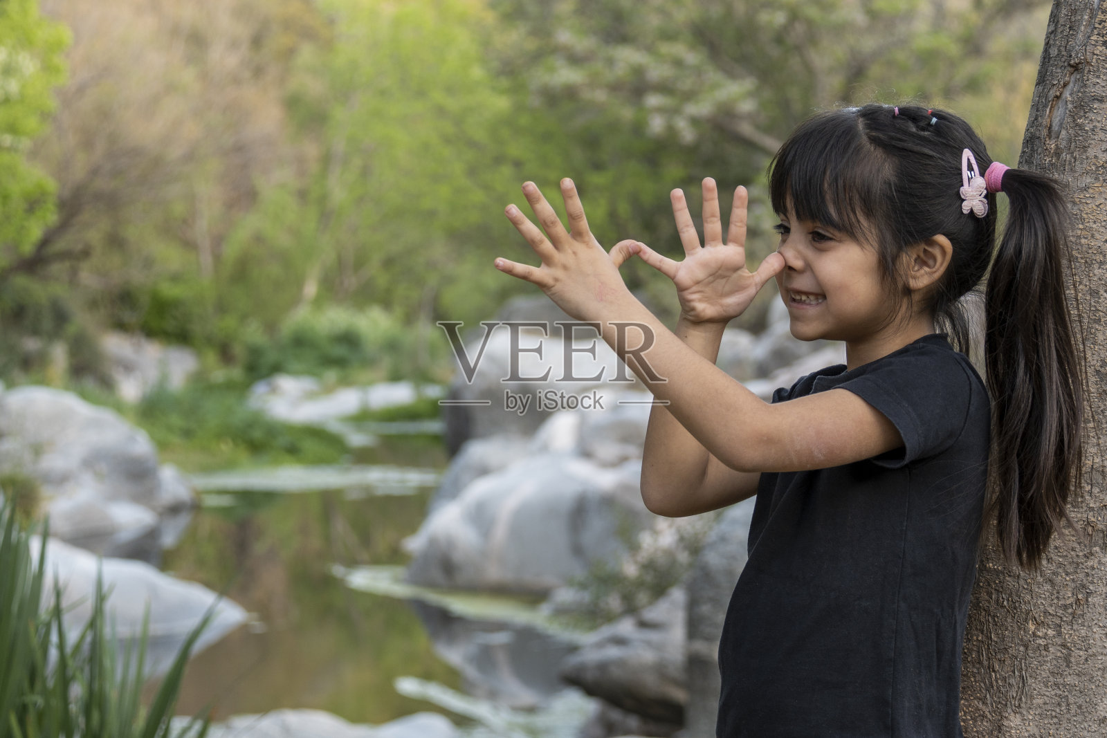 小女孩在小溪里玩耍。照片摄影图片