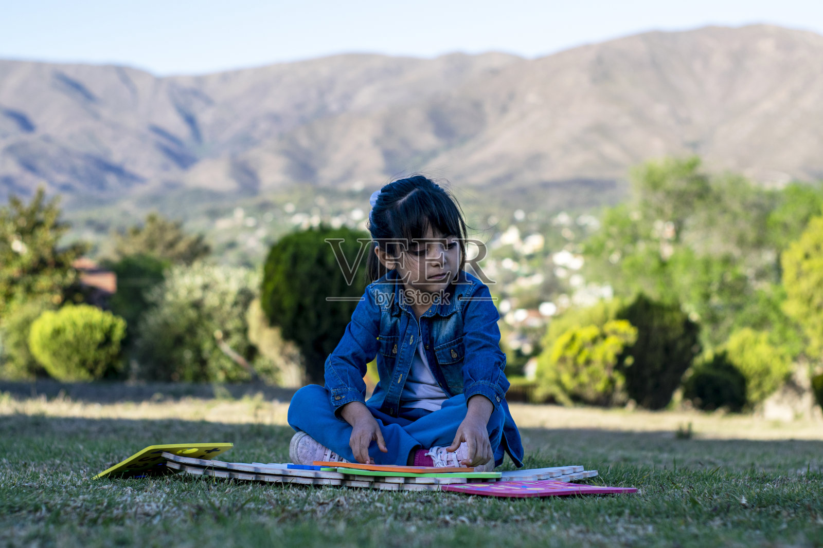 拉丁女孩在公园里做教育活动。照片摄影图片