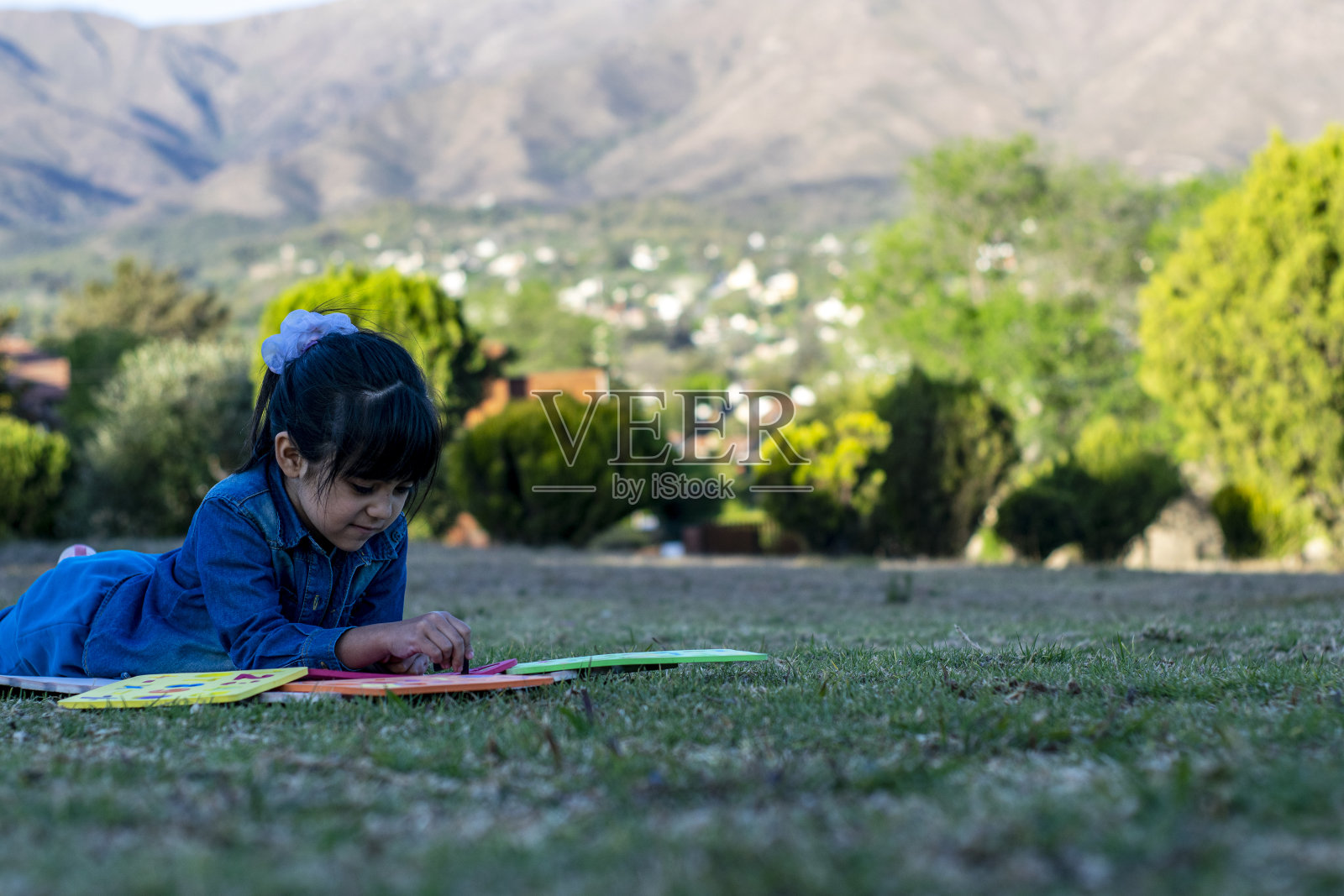 拉丁女孩在公园里做教育活动。照片摄影图片