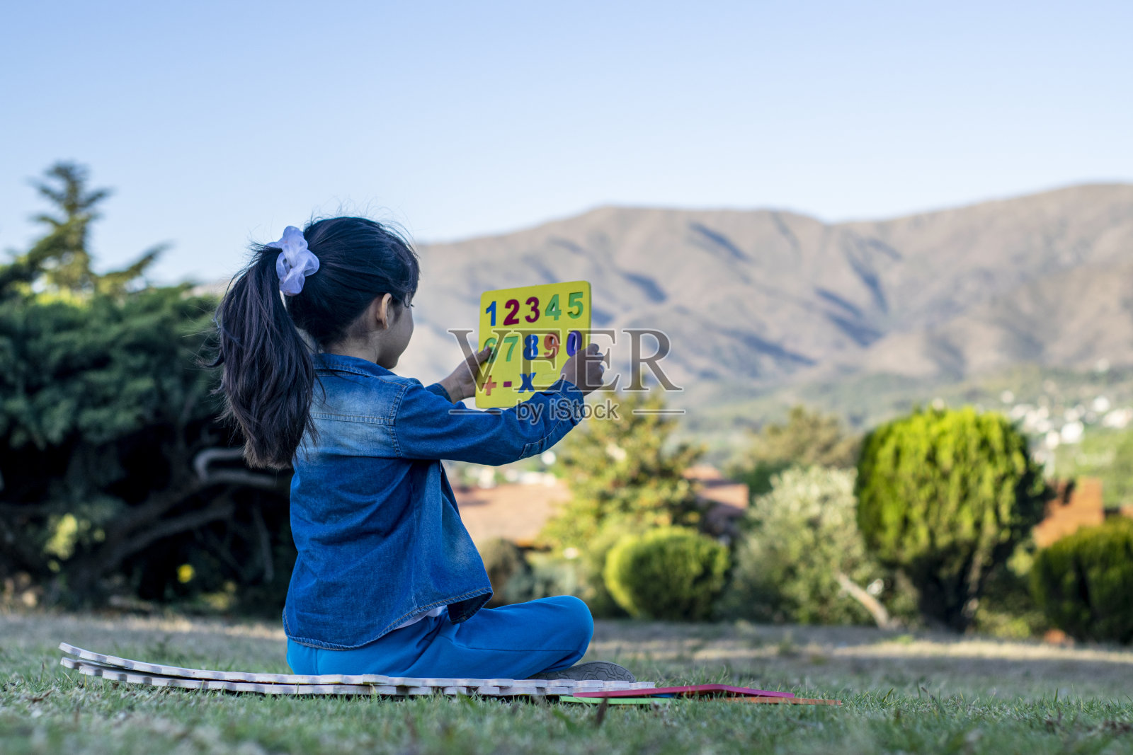 拉丁女孩在公园里做教育活动。照片摄影图片