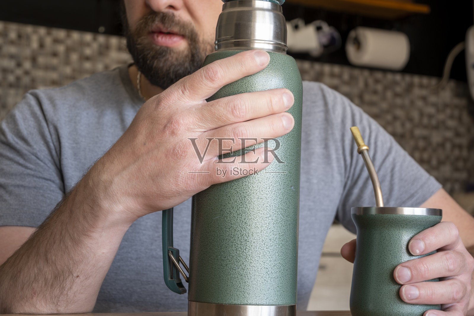 拉丁男人在厨房里喝马黛茶。照片摄影图片