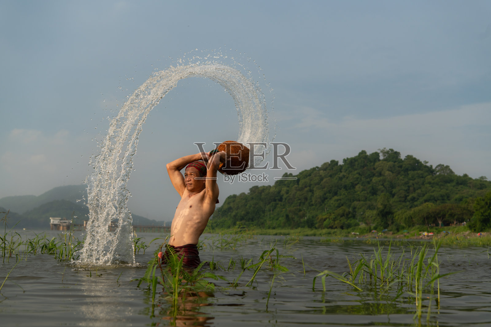 渔民使用传统的捕鱼设备捕鱼后，清理和在水里玩耍。照片摄影图片