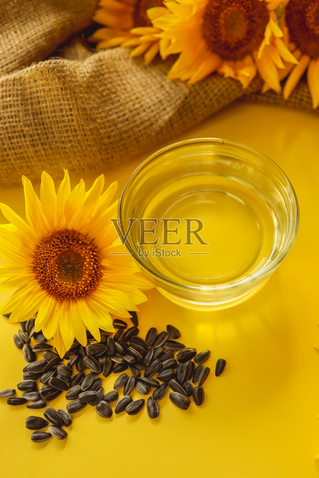 向日葵油，种子和花在黄色的背景照片摄影图片