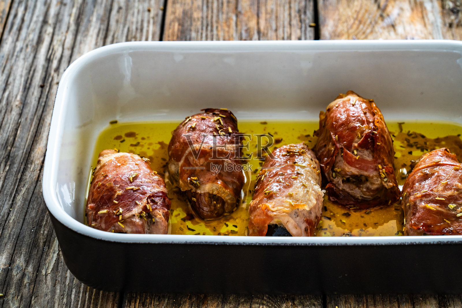 酿猪里脊配李子干，裹着腌制火腿照片摄影图片