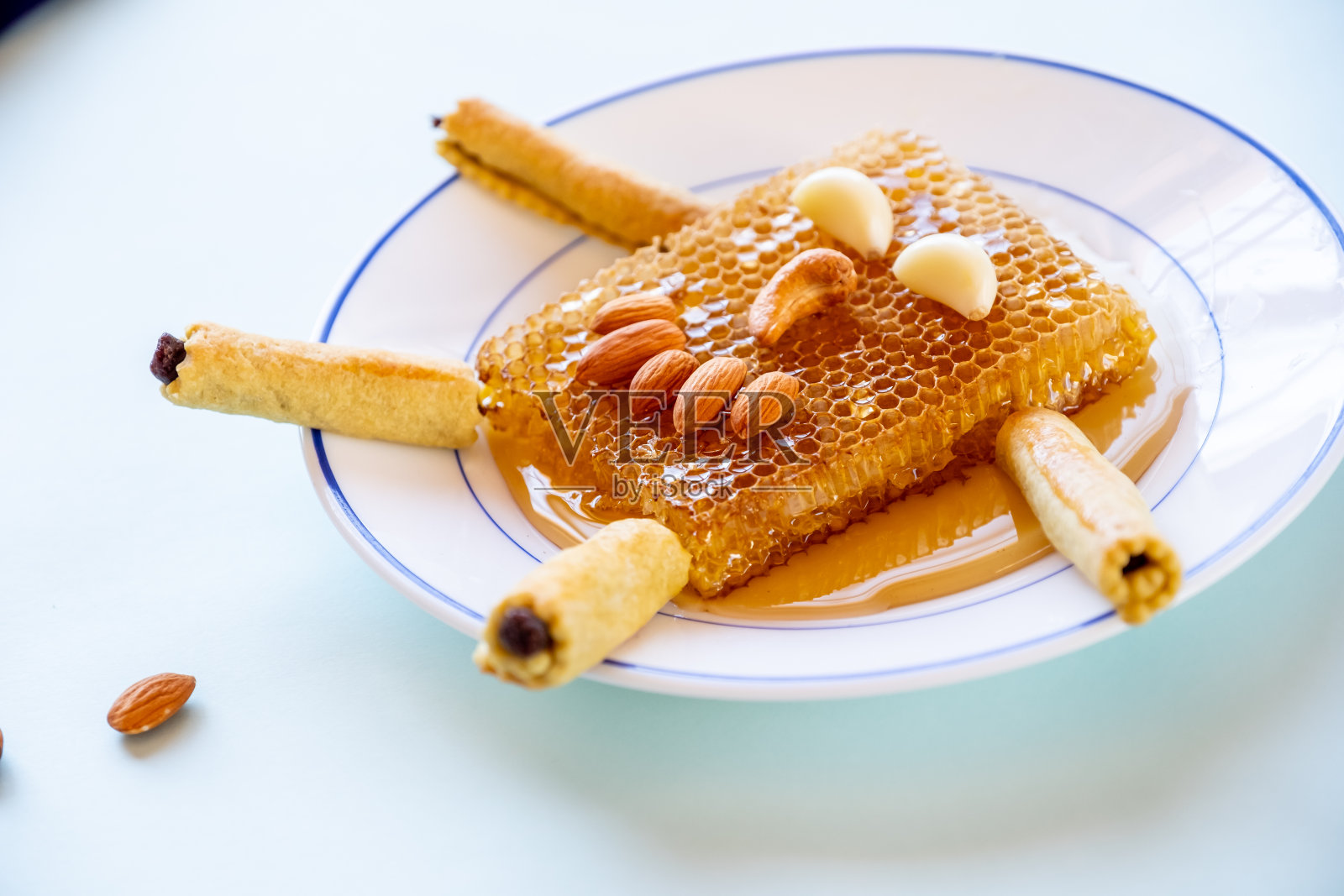 蜂蜜蜂巢、杏仁和枣泥馅饼制成的笑脸，配以青柠和橙子照片摄影图片