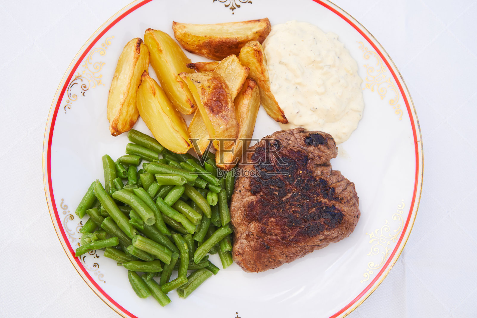 乡村风格的烤制牛排瓷盘上的俯视图图片。照片摄影图片