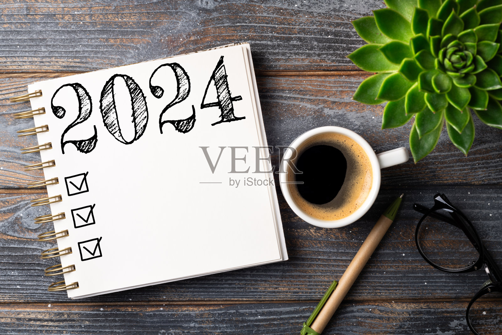 2024年新年计划在办公桌上。2024年决心清单，笔记本，咖啡杯放在桌子上。目标，决议，计划，行动，清单概念。2024年新年模板照片摄影图片