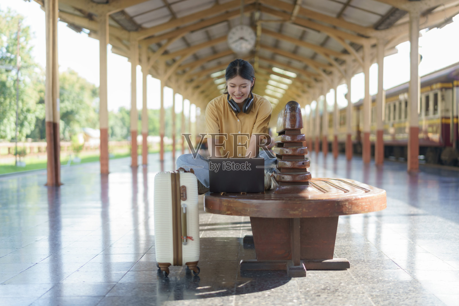 旅行前在火车站工作的年轻自由职业者。工作和旅行的概念。照片摄影图片