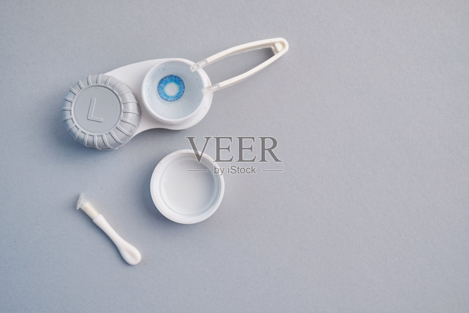 彩色镜片在一个容器和配件在浅色背景。健康医药理念照片摄影图片