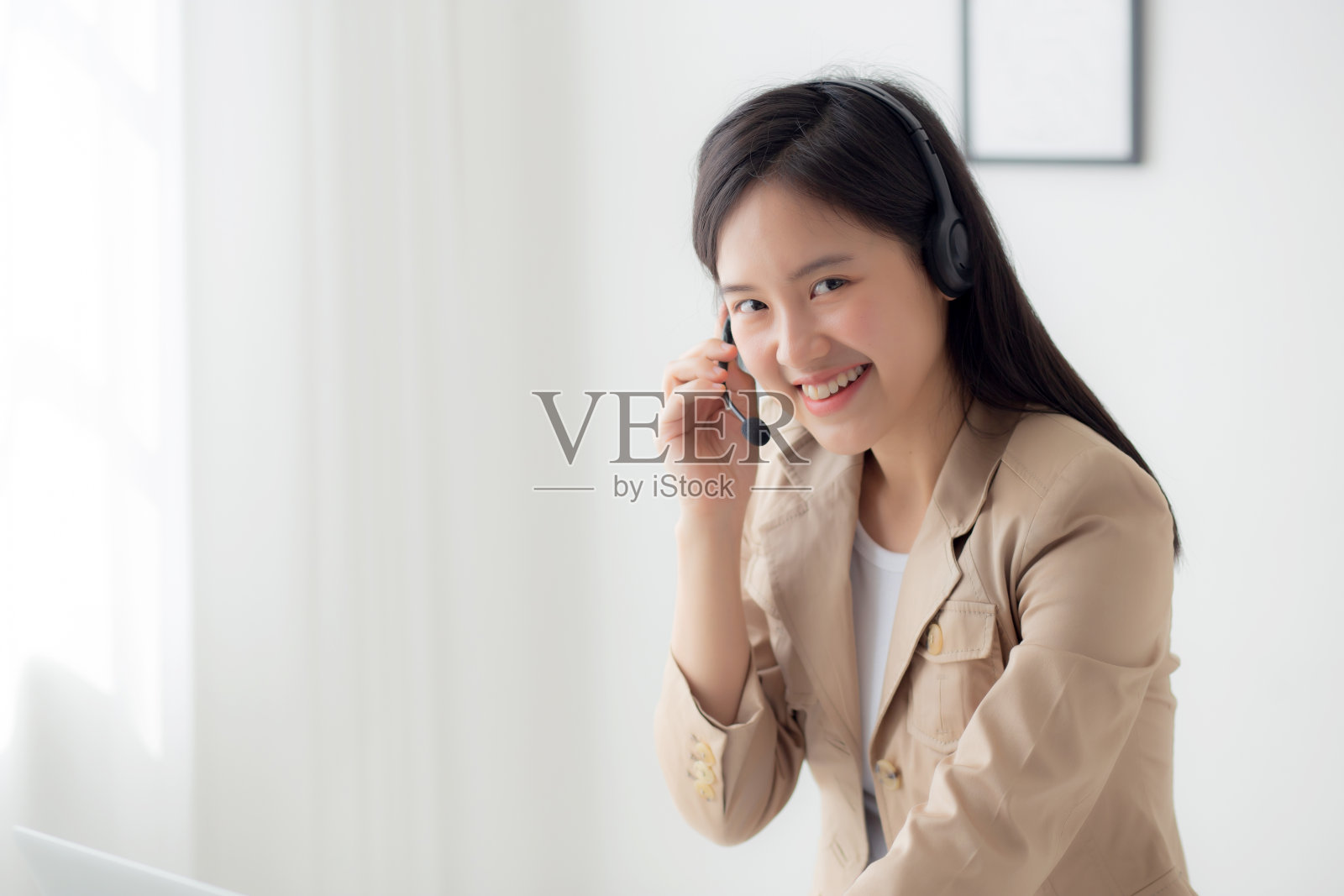 年轻的亚洲女商人戴着耳机在家进行视频通话和在线讲解会议，女性戴着耳机在家开会和谈话，商务和沟通概念。照片摄影图片