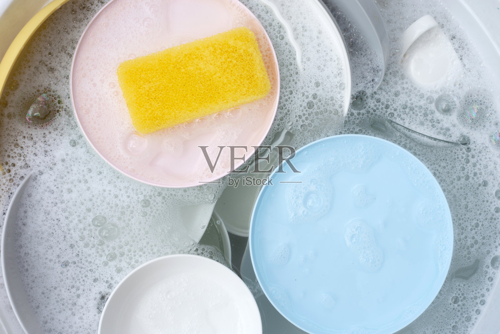 盘子和碗泡在水里和泡在洗洁精里。厨房工作照片摄影图片