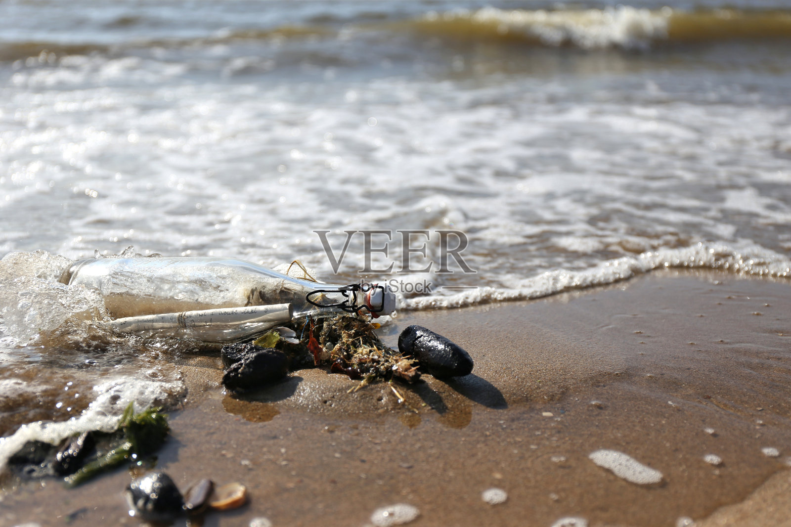 漂流在海滩上的瓶子里的信息照片摄影图片