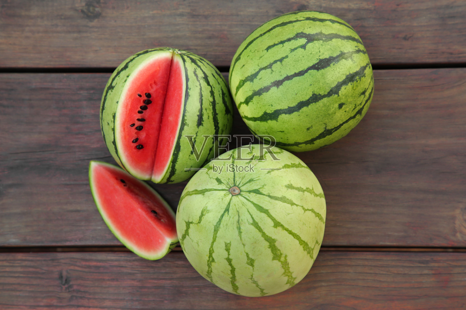 不同美味的熟西瓜放在木桌上，平躺着照片摄影图片
