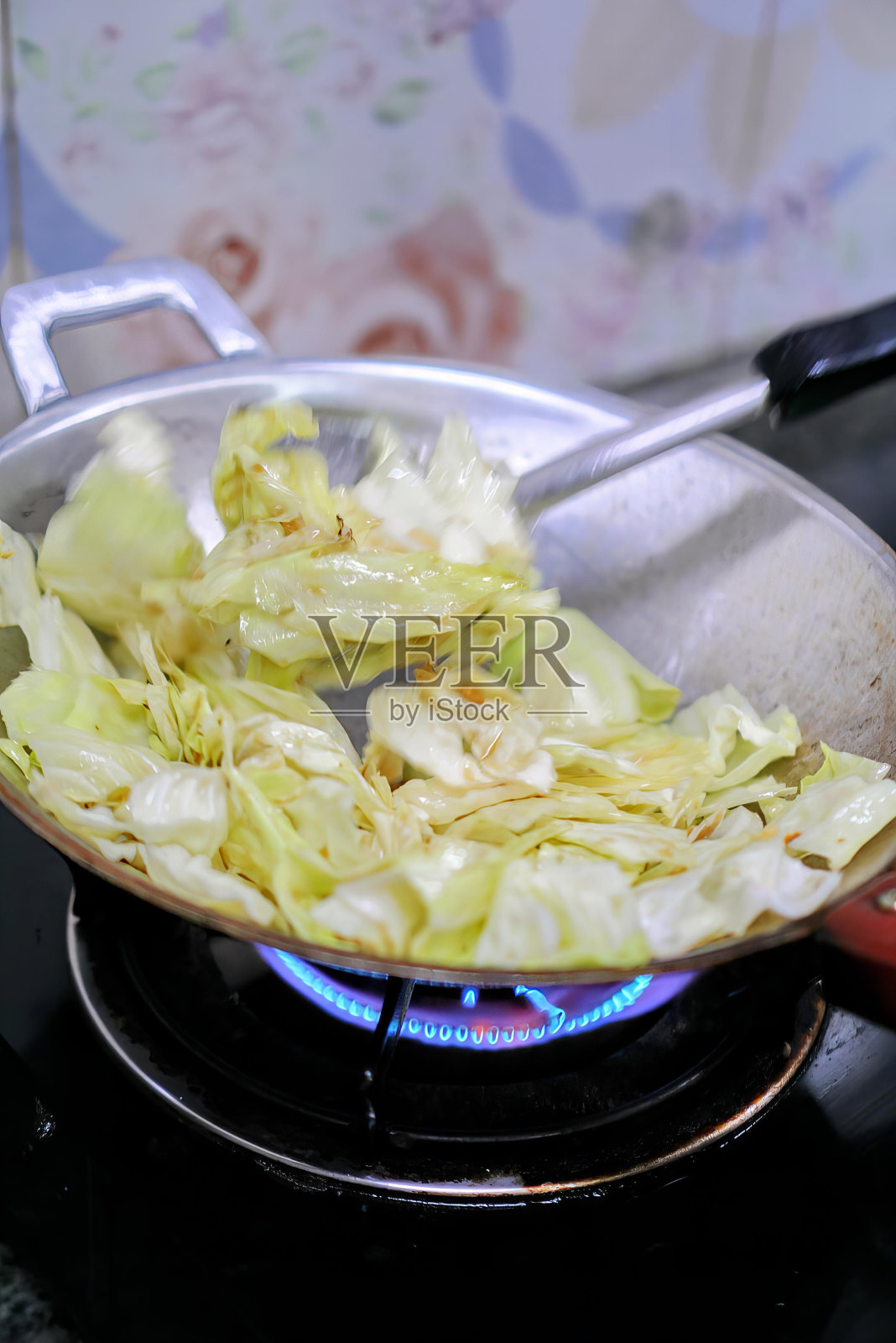 在平底锅里煮生菜。照片摄影图片