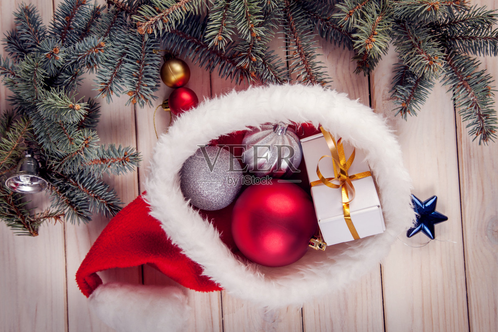 在雪地里的桌子上摆放着圣诞装饰品，背景是圣诞彩灯照片摄影图片