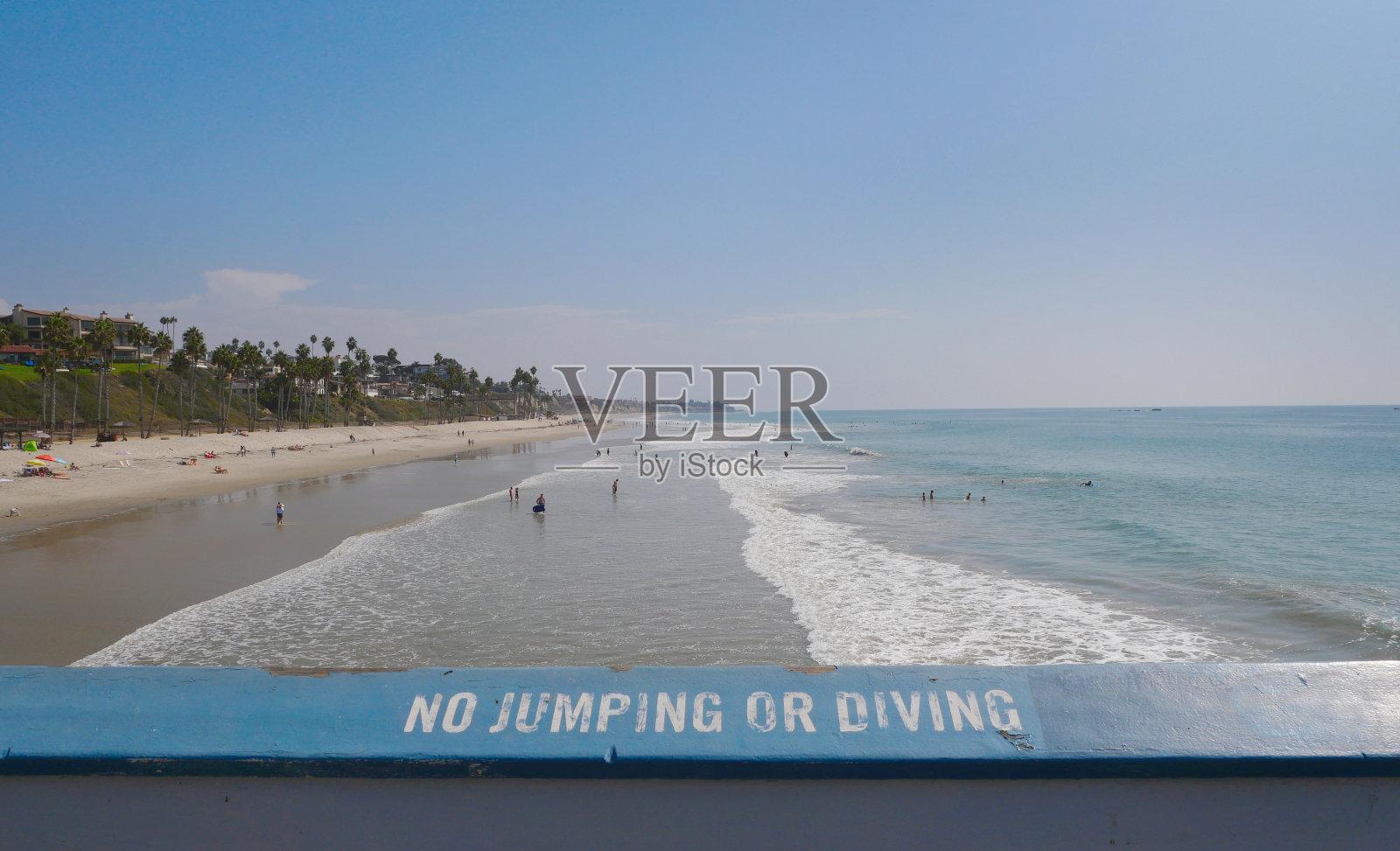 圣克莱门特码头的栏杆上写着“禁止跳跃或潜水”，面朝海滩和太平洋照片摄影图片