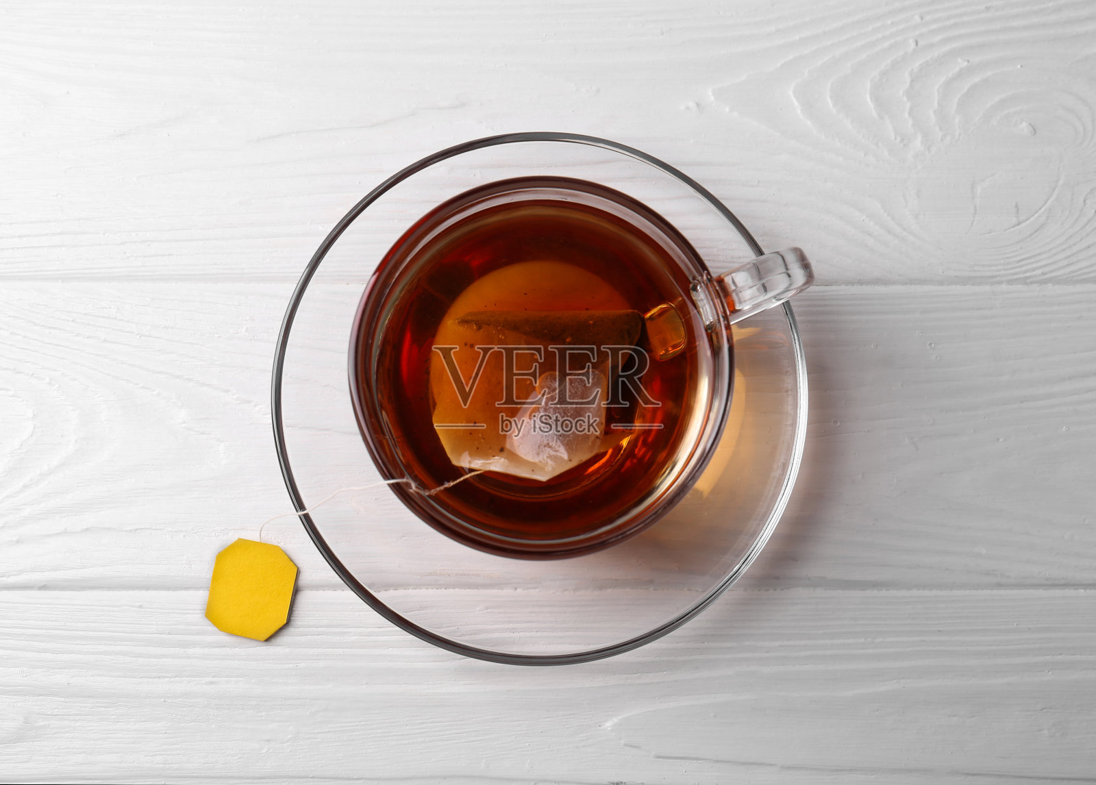 白色木桌上的玻璃杯装茶包，俯视图照片摄影图片