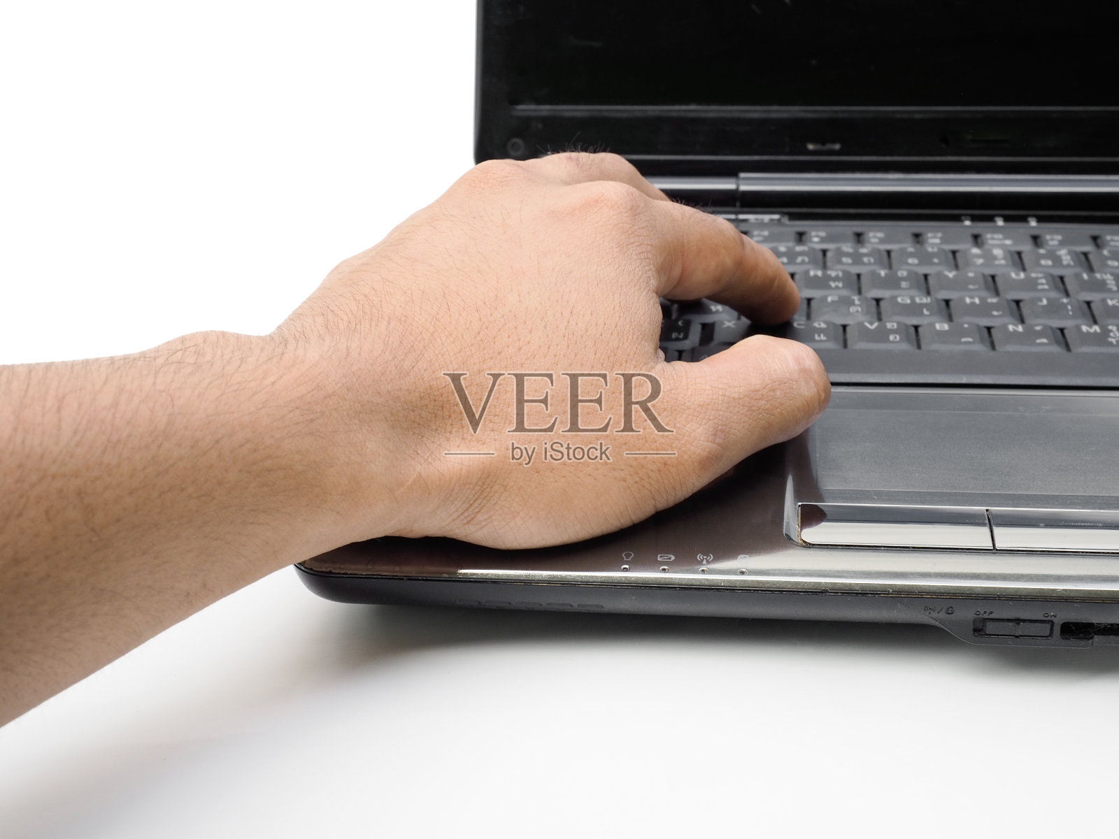 人类的双手坐在白色的工作桌上，在笔记本电脑的键盘上打字。在白色背景上孤立的商业理念。照片摄影图片