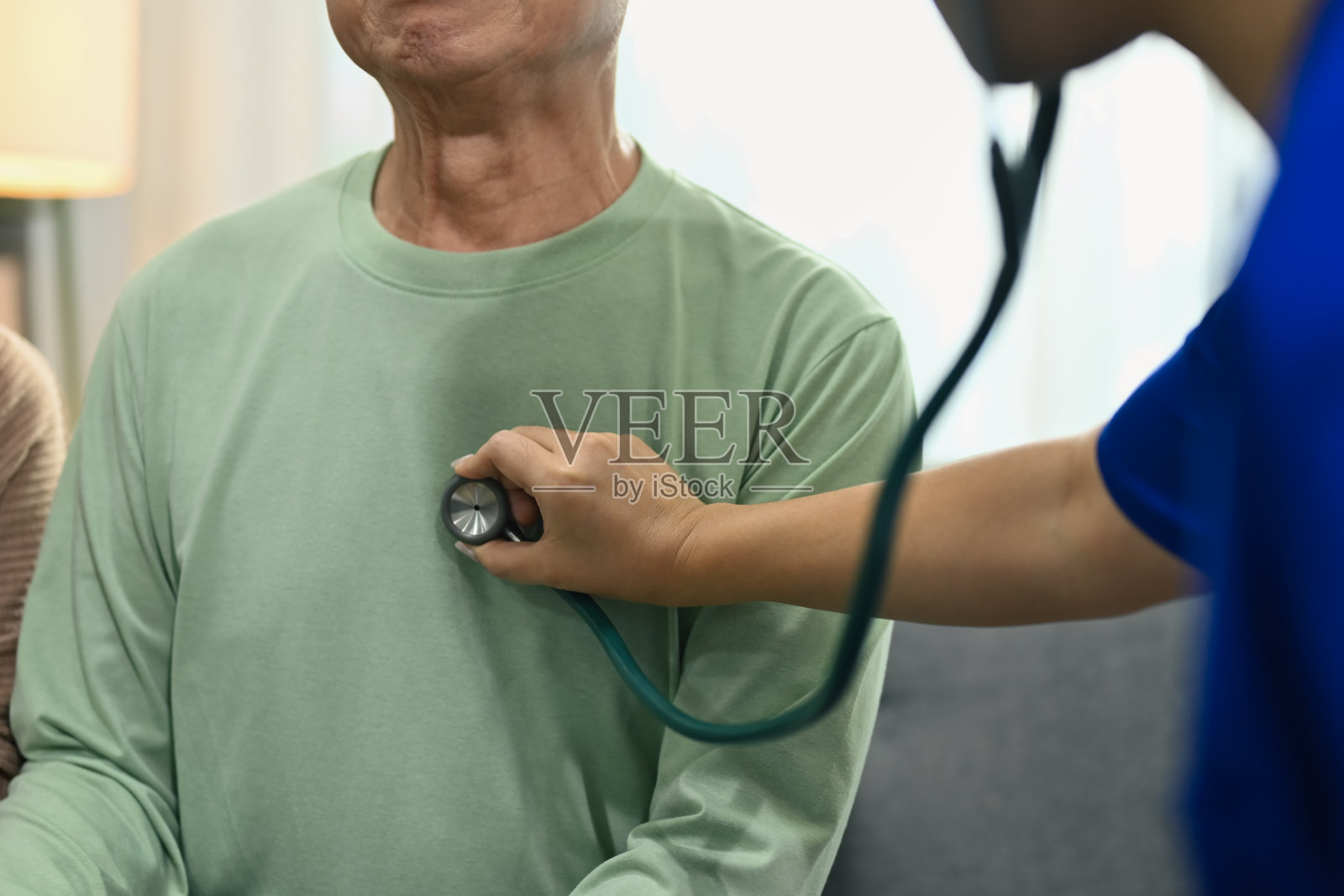 医生用听诊器听成熟男性患者的呼吸或心跳。健康护理理念照片摄影图片