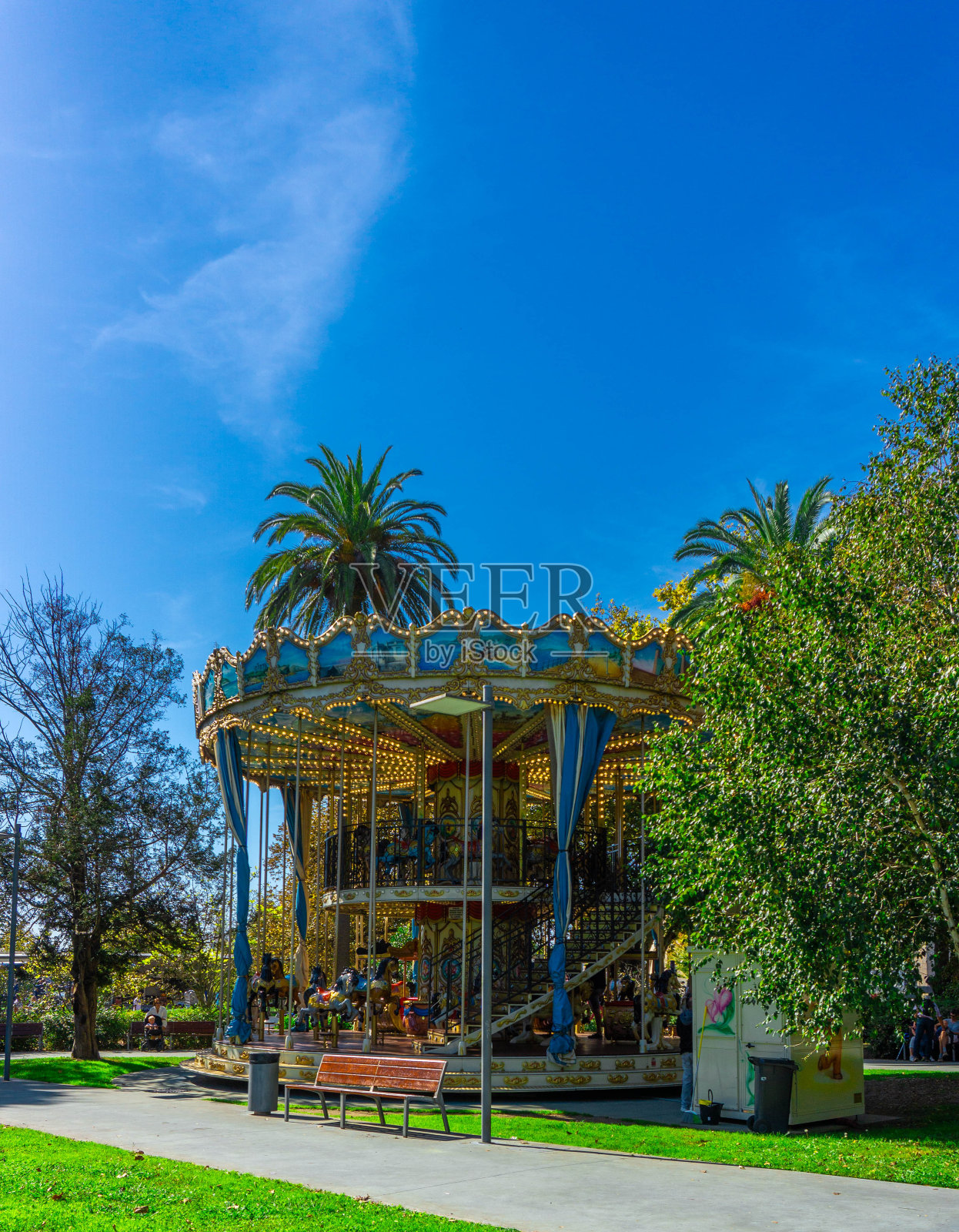 在阳光明媚的蓝天下，被郁郁葱葱的绿色景观和棕榈树包围的城市景观照片摄影图片