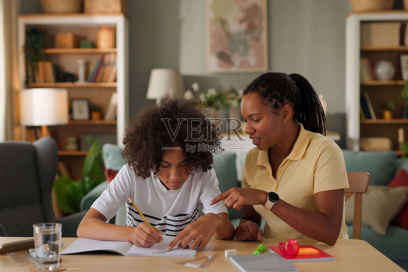 妈妈在家帮助十几岁的儿子复习考试照片摄影图片