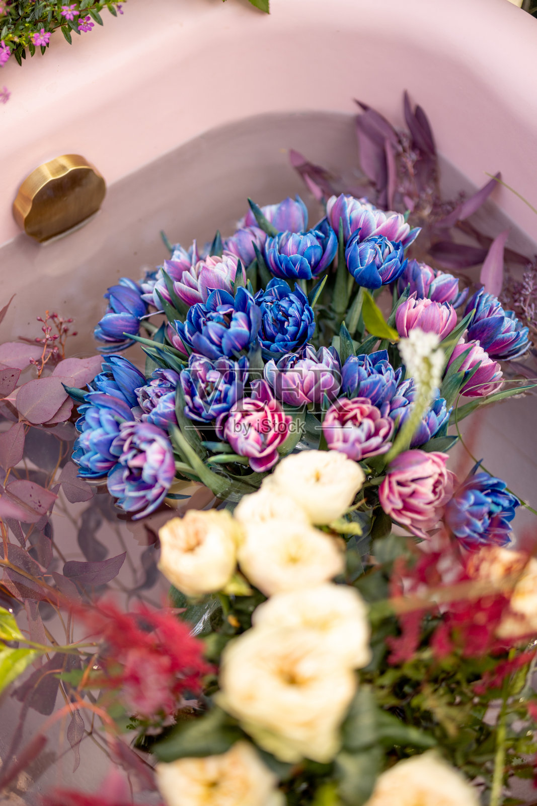 粉红色浴缸里五颜六色的切花照片摄影图片