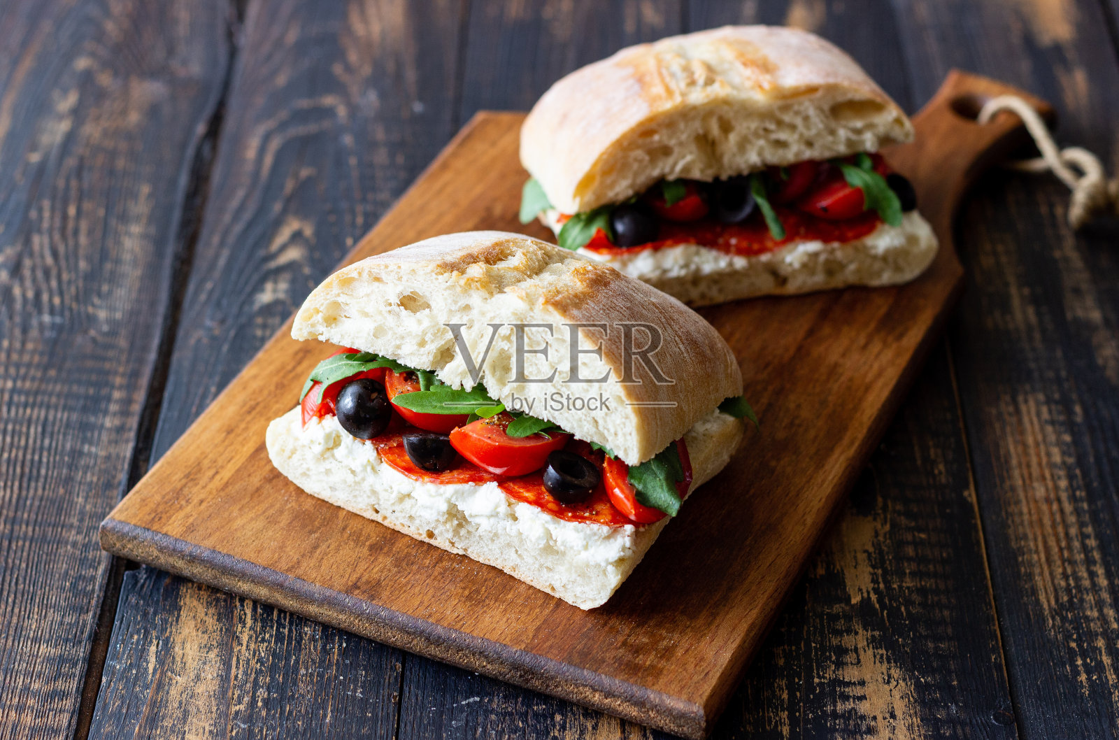 芝士，西红柿，香肠，橄榄和芝麻菜。三明治。意大利菜。照片摄影图片