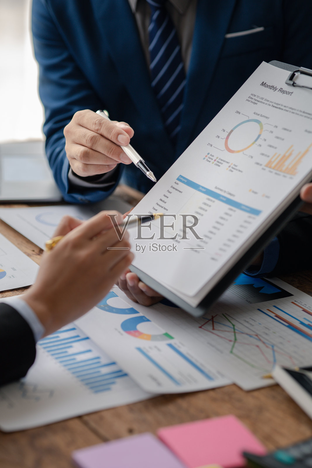 销售部门正在召开月度总结会议，将其提交给部门经理，他们在提交给经理之前核实准备的文件的正确性照片摄影图片