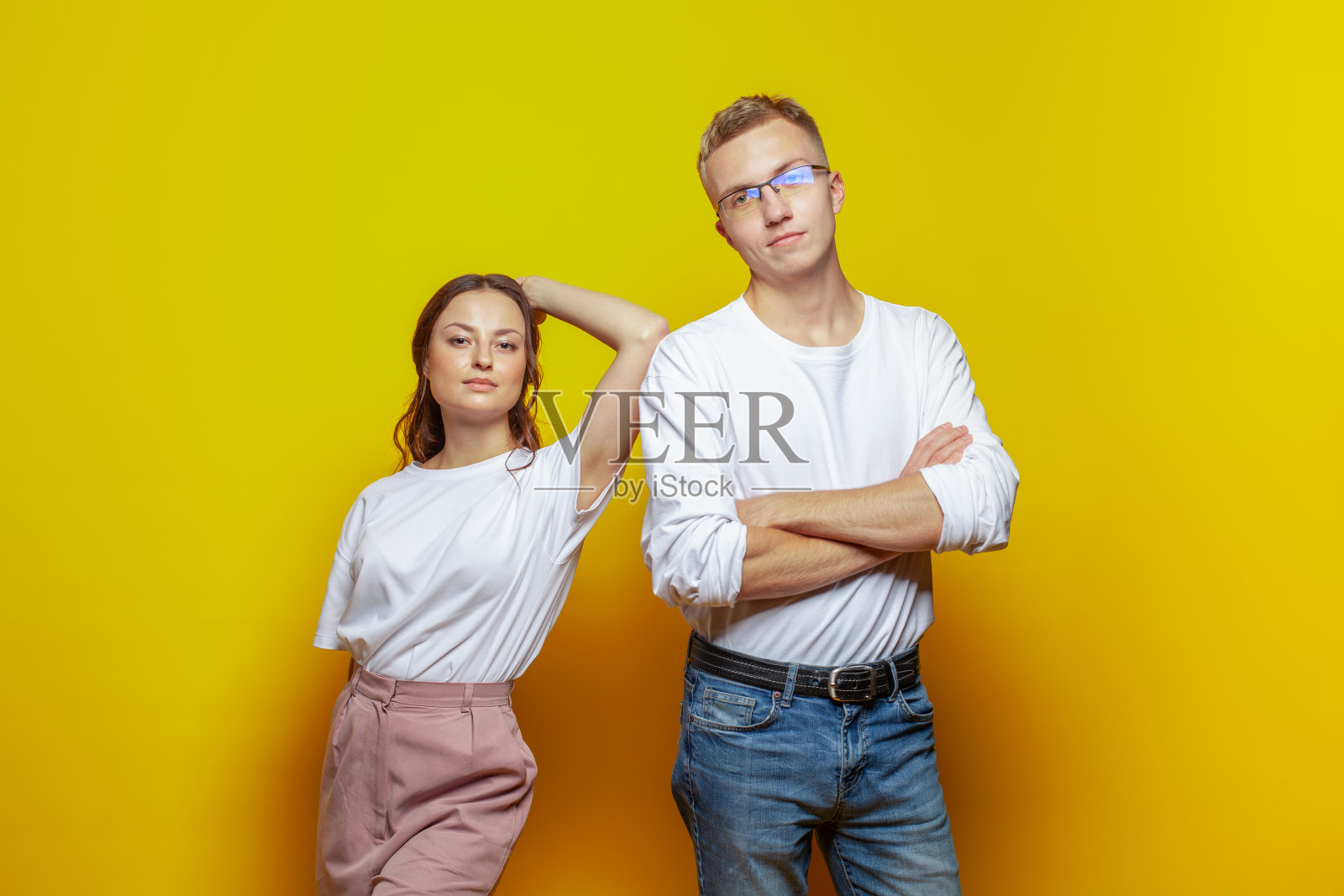 坚强的夫妇女人和男人站在明亮的橙色工作室墙壁背景照片摄影图片