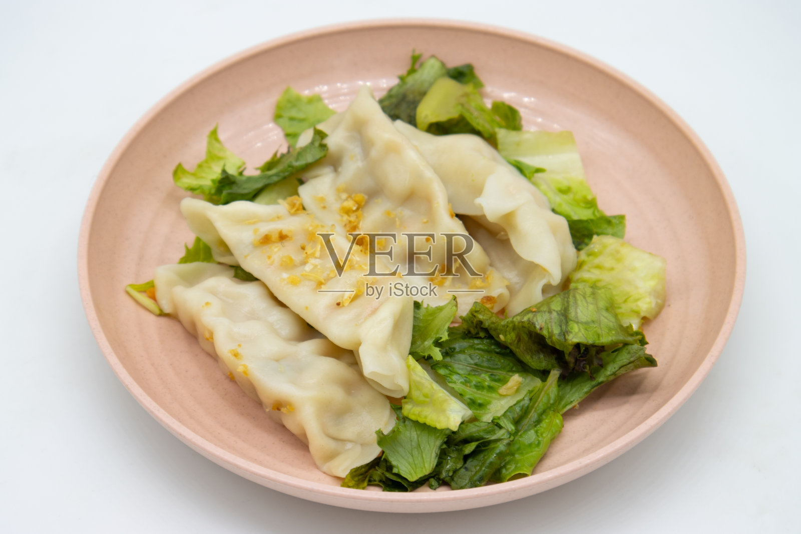 四个美味的中国蔬菜饺子与生菜在一个粉红色的盘子照片摄影图片