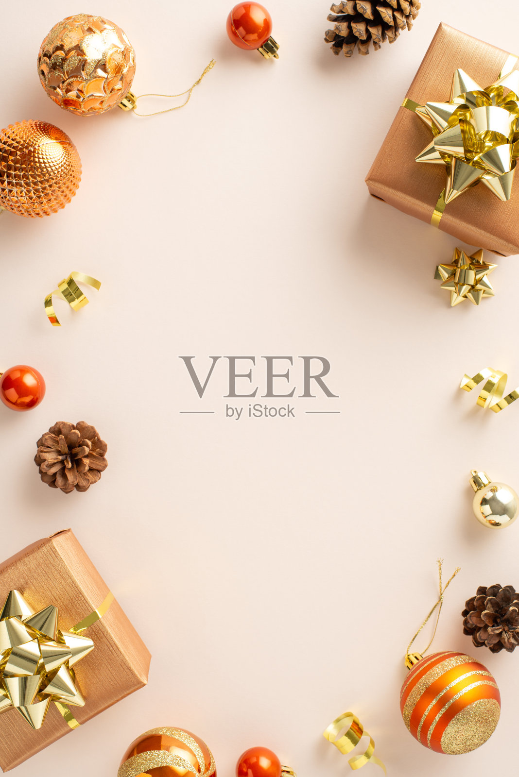 季节性魔术:垂直顶视图的礼品包装，闪闪发光的橙色和金色饰品，松果，和蛇纹在一个柔和的米色背景，留下空间为您的信息或广告照片摄影图片