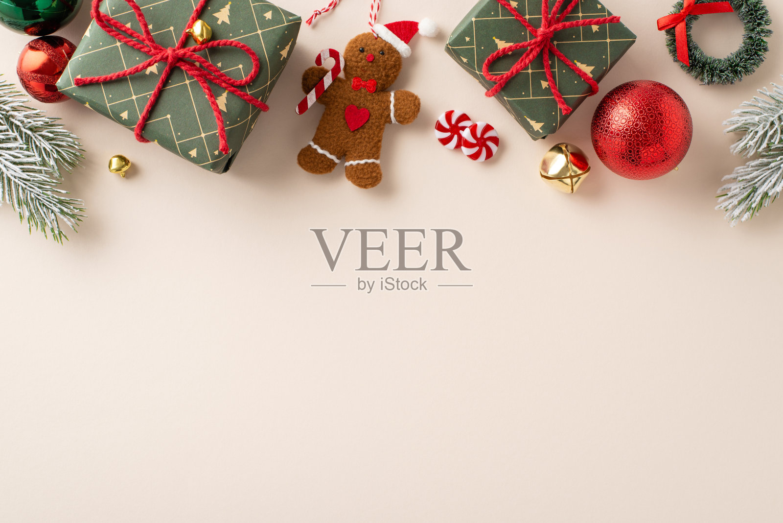 从空中捕捉节日气氛，绿色的礼盒、红色和绿色的球、姜饼人树装饰品、叮当响的铃铛、小花环、糖果、霜冷杉树枝在灯光的背景下照片摄影图片